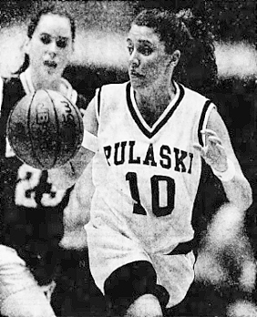 Pulaski County High's Heather Baker, state of Kentucky girl basketball player, in white Pulaski $10 uniform coming upcourt towards us after stealing thw nall from Belfry High' Camille Kline, number 23 seen in the backgroun, in the state tournament game where Baker scored 46 points. From The Courier-Journal, Louisville, Kentucky, March 22, 1996.