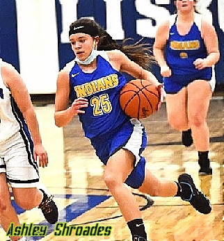 Action photo of girls basketball player, Ashley Shroades, Southern High School (Ohio), driving to the basket in blue INDIANS uniform #25.