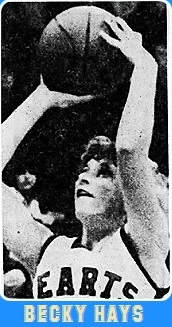 Close-up of Illinois girls basketball player, Becky Hays, Effingham High School, in her white HEARTS uniform, shooting an overhead shot at the basket. From the Decatur Herald, Decatur, Illinois, March 10, 1980.