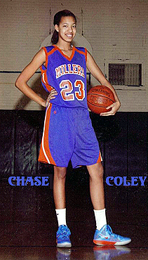 Image from 2013 of Chase Coley, girls high school basketball player for the Wasburn Millers, standing, with a basketball on her hip, in her number 23 Millers uniform.