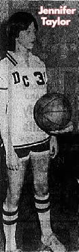 Image of girls basketball player, Jennifer Taylor, David Crockett High School, Tennessee, standing facing right, hands down, in uniform, being handed basketball from her coach. Cropped from the Johnson City Press-Chronicle, December 14, 1978.