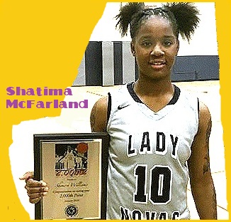 Image of Shattima McFarland, Wisconsin Pulaski High girls basketball player, holding plaque after scoring career 2,000th point. In light grey uniform LADY NOVA #10.